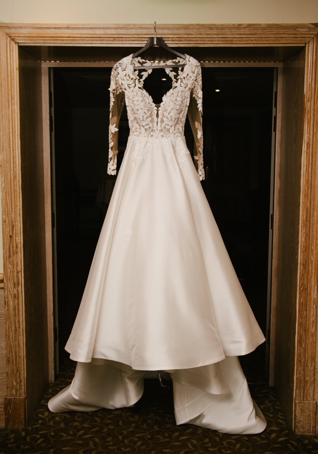 Lily’s wedding dress hanging in a doorway