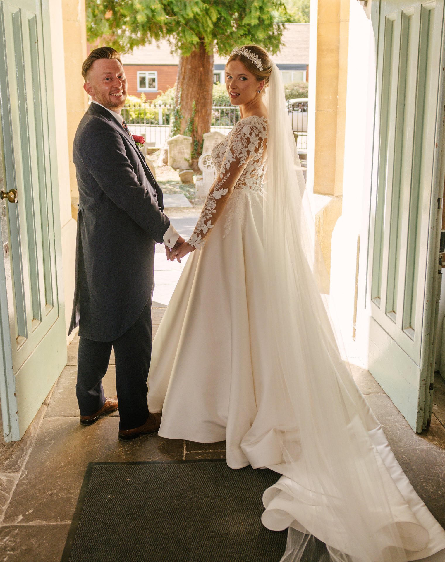 Lily and Piers holding hands in a doorway