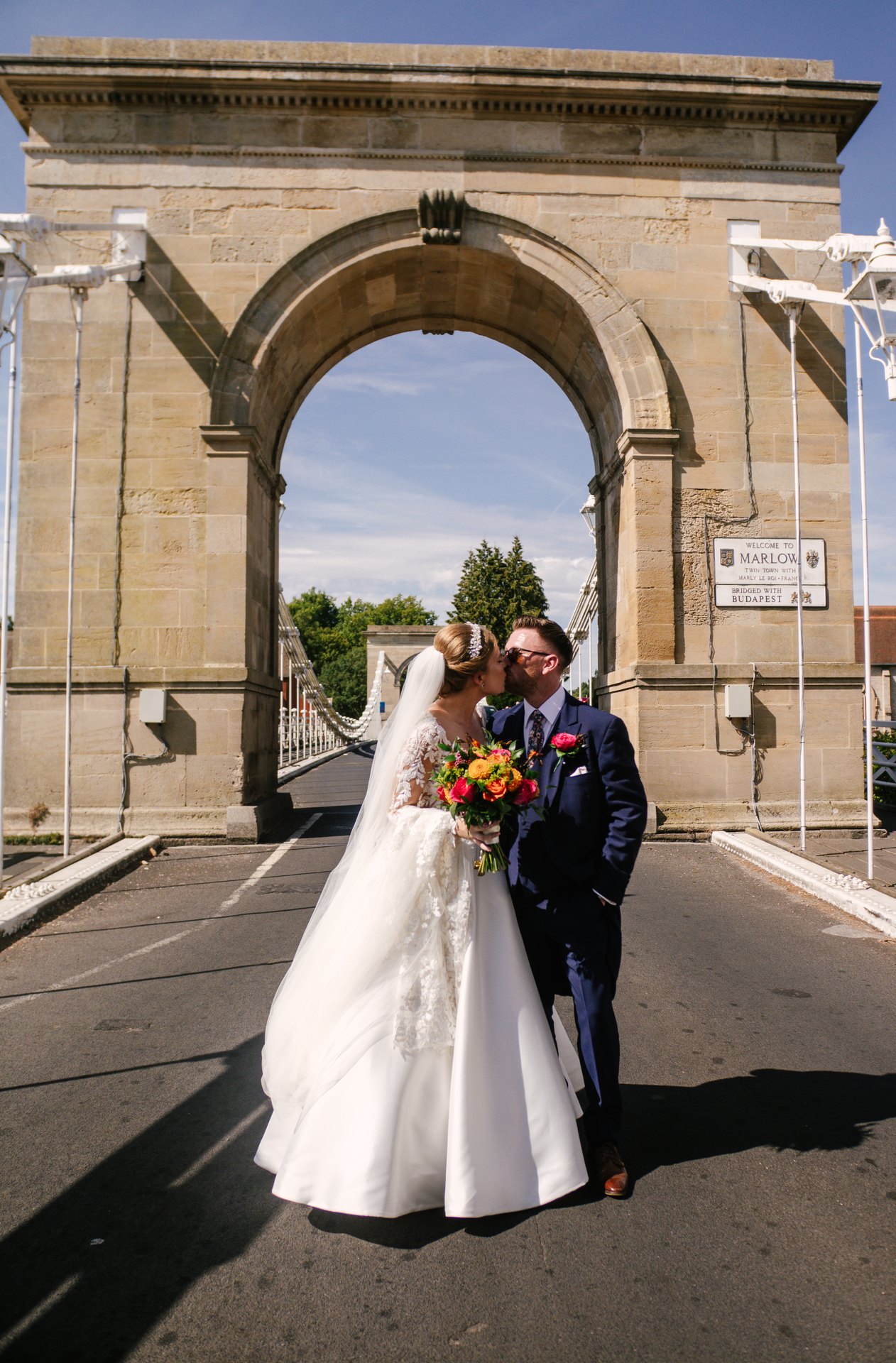Lily and Piers beneath an arch of Marlow Bridge