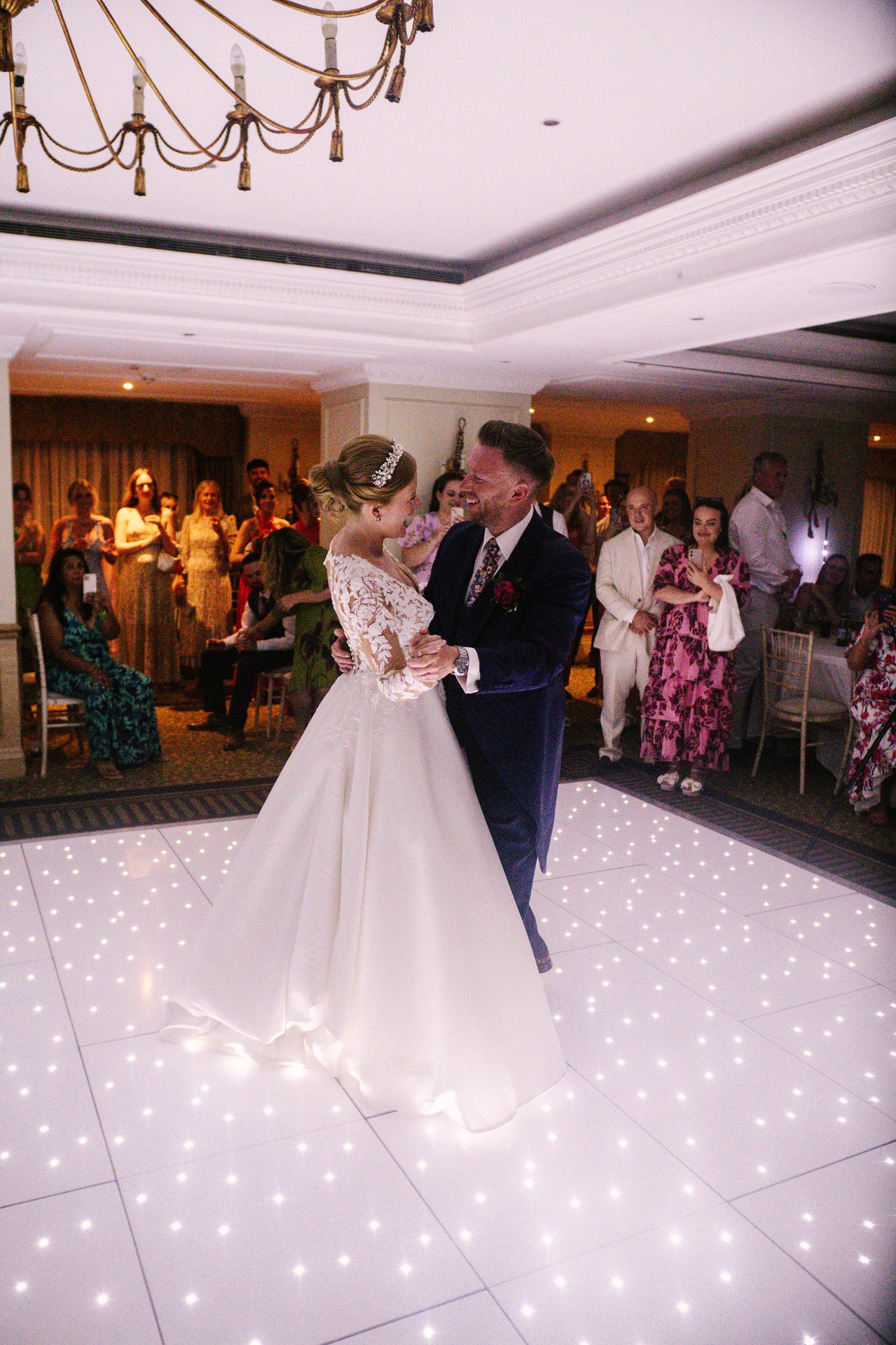 Lily and Piers dancing beneath a chandelier